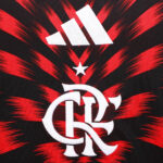 Interlocked white Flamengo crest (CRF) with a small white star above, on a red and black burst background and an Adidas logo at the top.