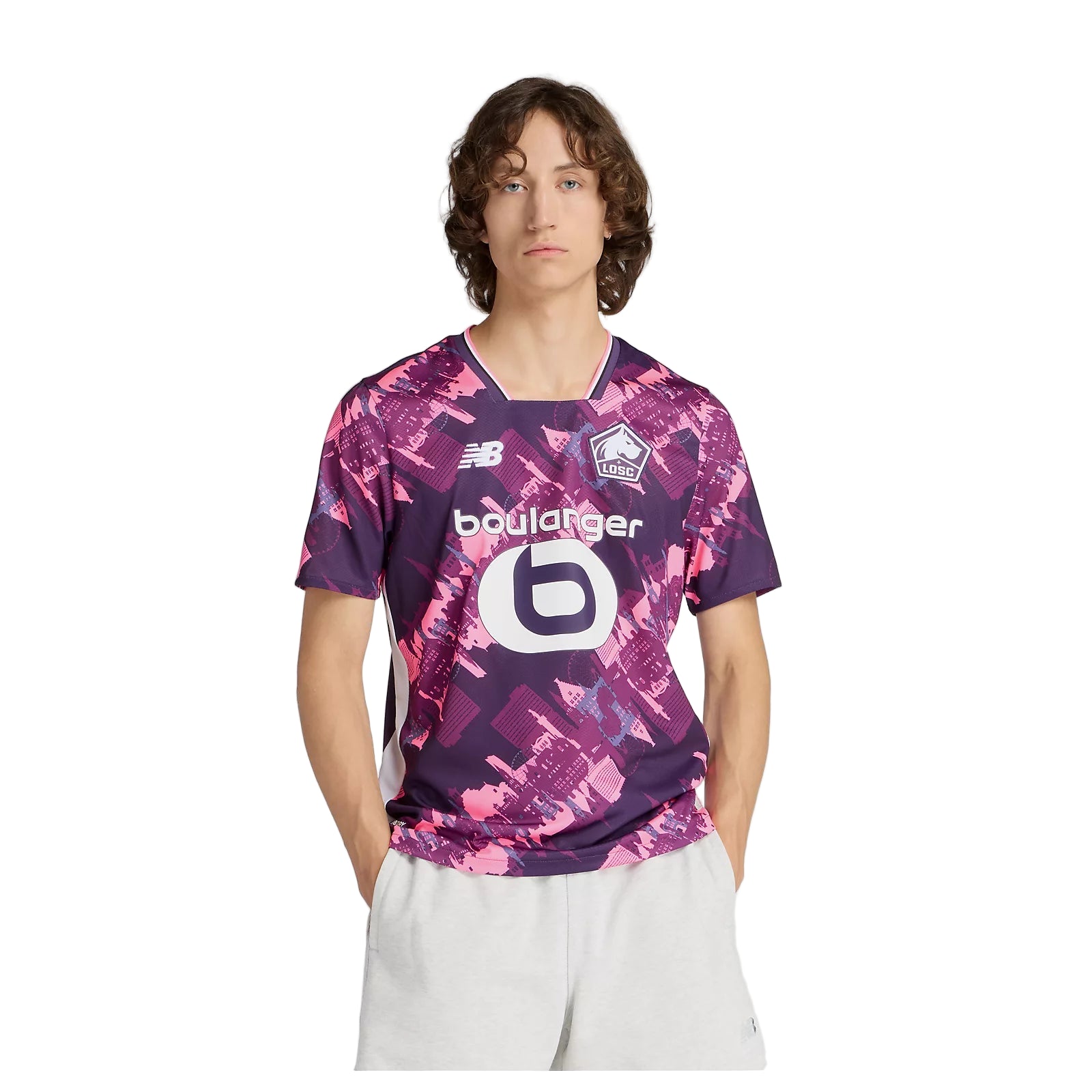 mt230457fou_nb_70_i Young man wearing a purple-pink LOSC soccer jersey with sponsor logos, standing against a white background.