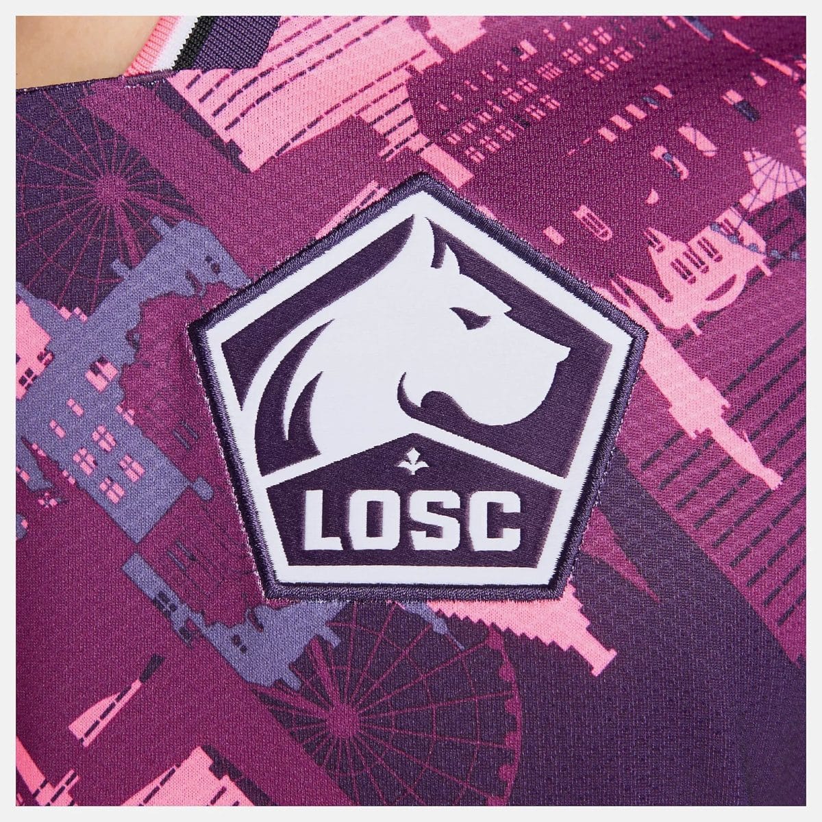 Close-up of a LOSC/Lille OSC shield patch on a pink-purple patterned fabric.