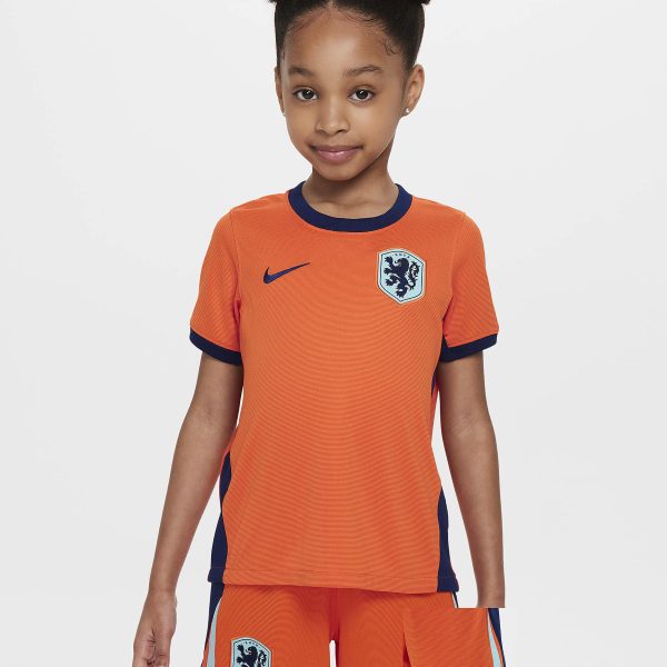 Young girl wearing an orange Netherlands soccer jersey with blue trim and crest against a light background.