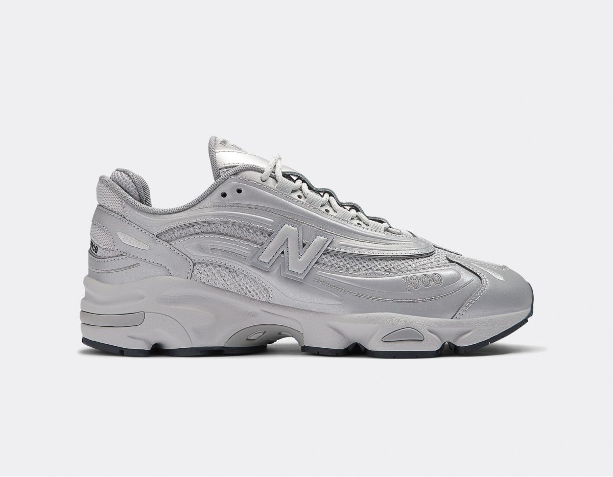 Side view of a bulky gray athletic sneaker with a thick sole and stitched panels, featuring an NB 'N' logo and '1000' on the toe area