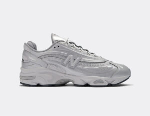 Side view of a bulky gray athletic sneaker with a thick sole and stitched panels, featuring an NB 'N' logo and '1000' on the toe area