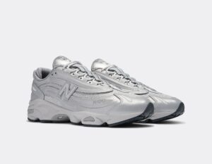 Pair of gray athletic sneakers shown from the side on a light background, with chunky soles and laces tied.