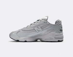 Side view of a light gray New Balance running shoe with the bold 'N' logo and textured panels on the upper.
