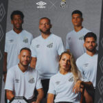 Group portrait of six soccer players in white Santos FC jerseys with Umbro logo, posing for a team photo.