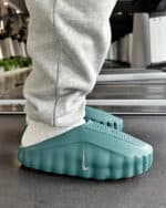 Recovery slides in teal with Nike swoosh logo for comfort and relaxation.