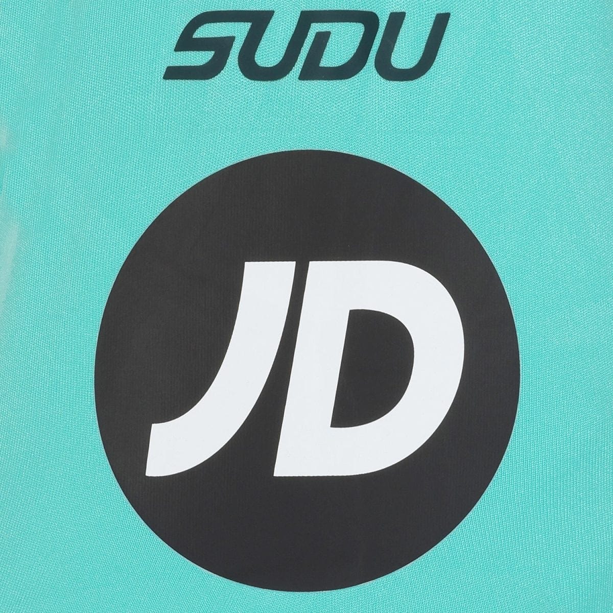 Close-up of teal fabric with a large black circle containing a white 'JD' logo.