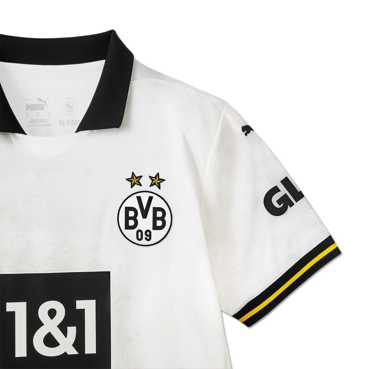 White Borussia Dortmund football jersey with black collar, featuring the BVB crest with two gold stars on the chest and a black 1&1 sponsor block, partial sleeve logo visible.