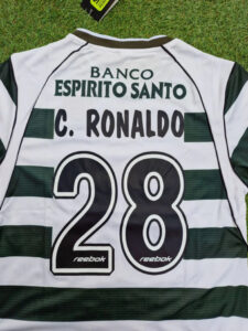 Back view of a white and green striped soccer jersey showing sponsor Banco Espírito Santo, a name on the back, and the large number 28 (brand: Reebok).
