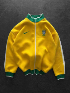 Yellow Brazil national team jacket with a green collar and white zipper, featuring a Nike swoosh on the chest.