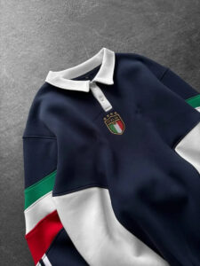 Navy polo shirt with a white collar and an Italian crest on the chest. The sleeves show green, white, and red color blocks.