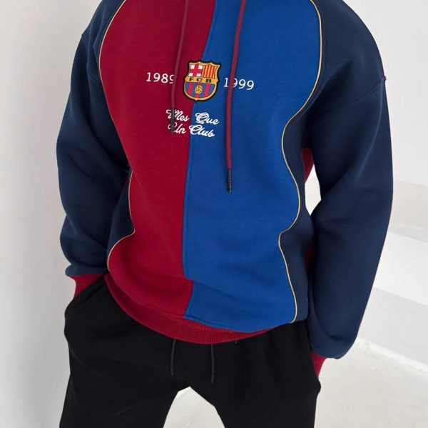 Man wearing a color-block red and blue FC Barcelona hoodie with crest and white text on the chest