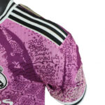 Close-up of a purple soccer jersey sleeve with a black-and-white striped trim at the shoulder.