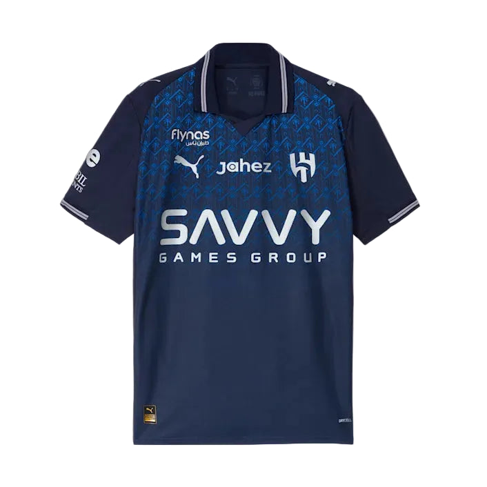 png_e4a40ceb-8653-43ac-bcd5-05dda5a7aa70 | UAE SPORT STORE Navy blue soccer jersey featuring the 'Savvy Games Group' sponsor across the chest, with Puma logo and team crest on the front, and patterned blue shoulders.