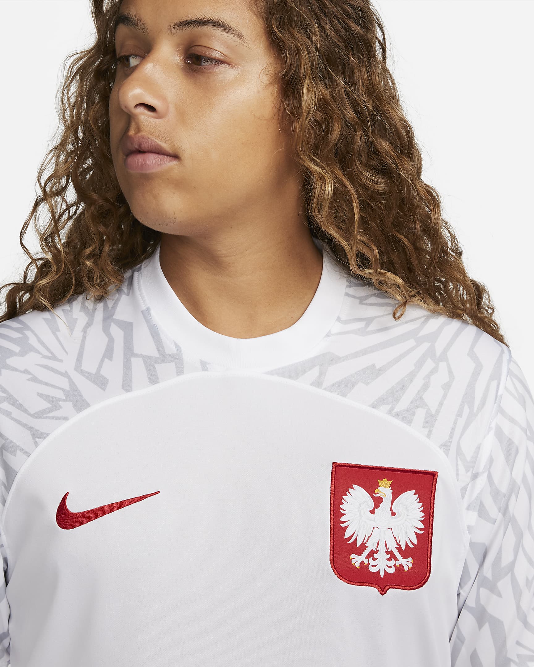 poland-2022-23-stadium-home-dri-fit-football-shirt-bwkVWB_71c3bf8e-c80c-496d-84bf-47fc5b69be50 | UAE SPORT STORE Close-up of a white sports jersey showing a red Nike swoosh and the Polish eagle crest on the chest.