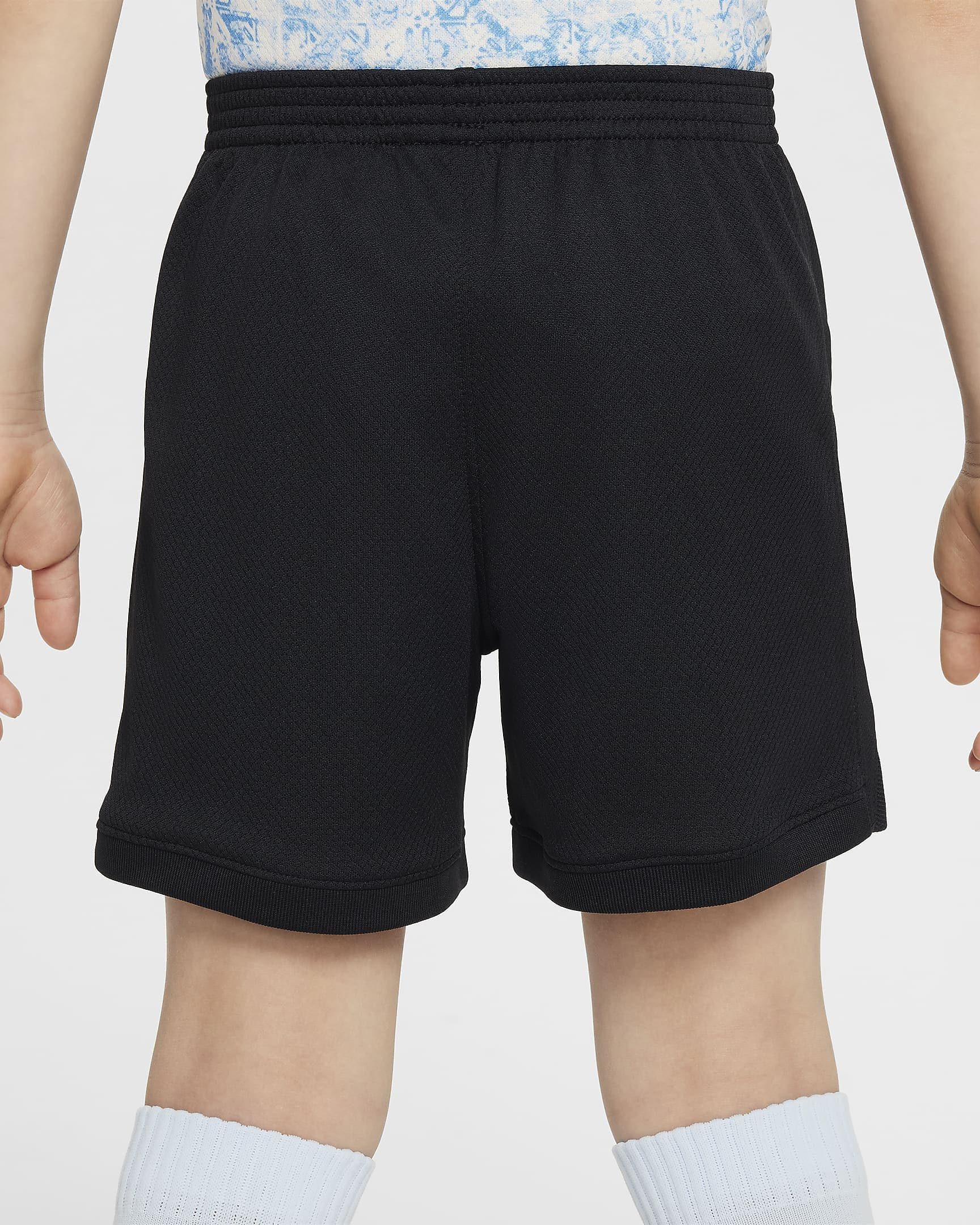 portugal-2024-stadium-away-younger-football-replica-3-piece-kit-4DZQMQ_8 | UAE SPORT STORE Back view of a person wearing black athletic shorts with a thick elastic waistband, blue patterned shirt, and light blue ribbed socks.