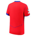 Back view of a red athletic jersey with blue trim on sleeves and hem, no visible front details.