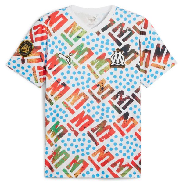 White OM football jersey with multicolored letters, blue polka dots, and Puma logo; club crest on chest.