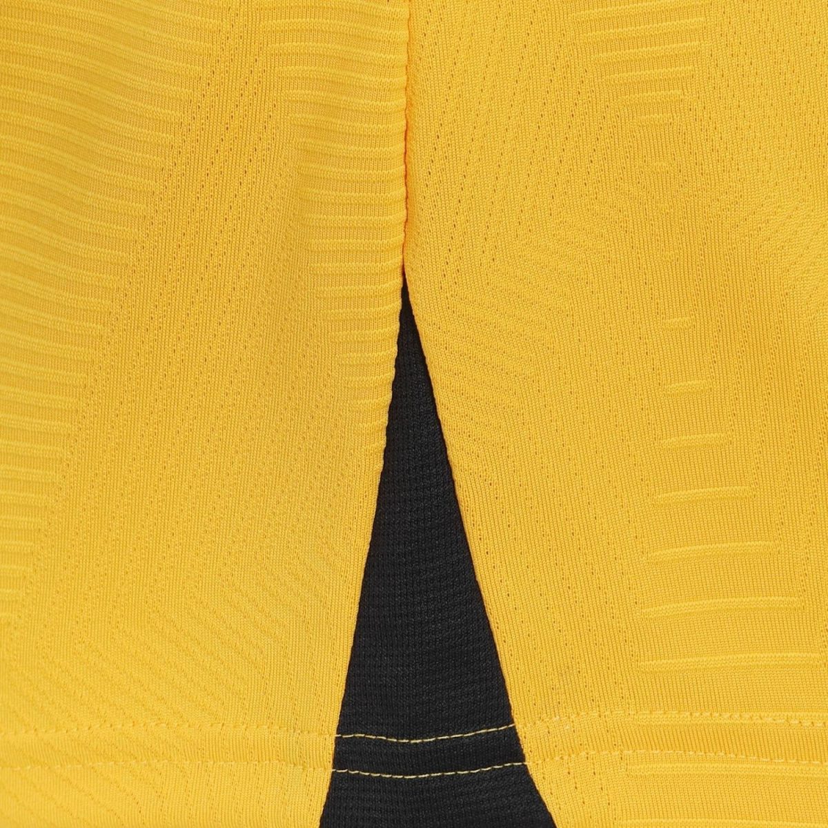 Close-up of a bright yellow knit cardigan with a black top visible through a V-shaped opening at the center.