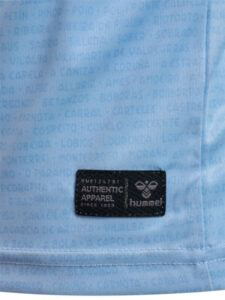 Light blue fabric with a small black label reading 'Authentic Apparel' and the Hummel logo sewn near the hem.