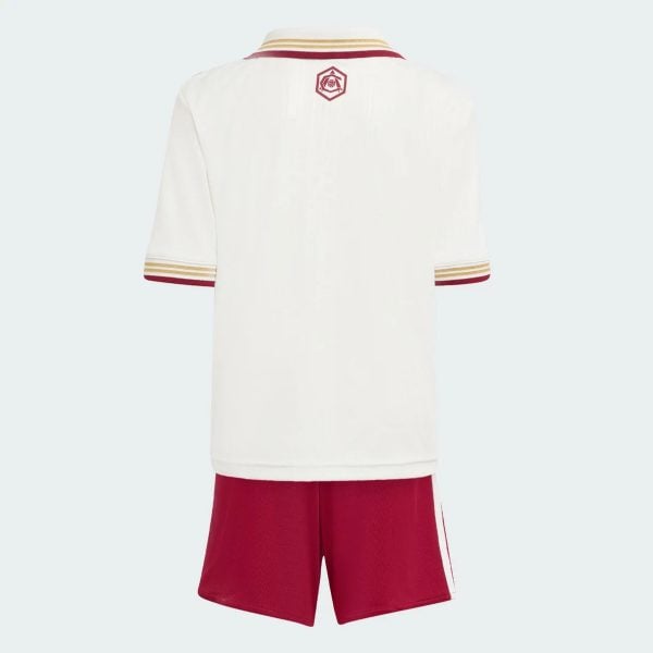 Back view of a white sports jersey with maroon and gold striped collar and sleeve cuffs, a small crest on the upper back, paired with red shorts.