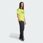 rDVBFGKaeLZlrhL | UAE SPORT STORE Person standing in a neon yellow Real Madrid soccer jersey and black pants, facing slightly right.
