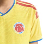 Yellow Colombia national football jersey with crest on chest and blue trim on sleeves and collar