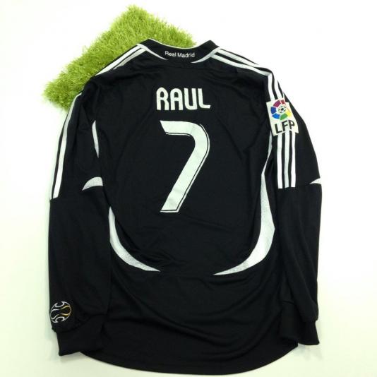Black Real Madrid jersey laid flat; back shows 'RAUL' and number 7 with LFP patch on the left sleeve.