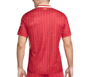 Back view of a person wearing a red sports jersey with gold geometric lines and a white-yellow collar.