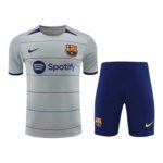 FC Barcelona away kit: light gray jersey with Spotify logo and club crest, paired with dark blue shorts.