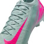 Close-up of a light teal athletic shoe with pink Swoosh and matching laces, showing a knitted upper.