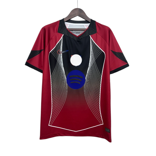 Red and black athletic jersey on a wooden hanger with geometric white line patterns on the front.