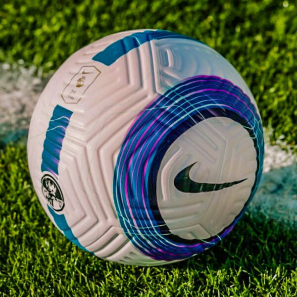 White Nike soccer ball with blue and purple circular design resting on green grass.
