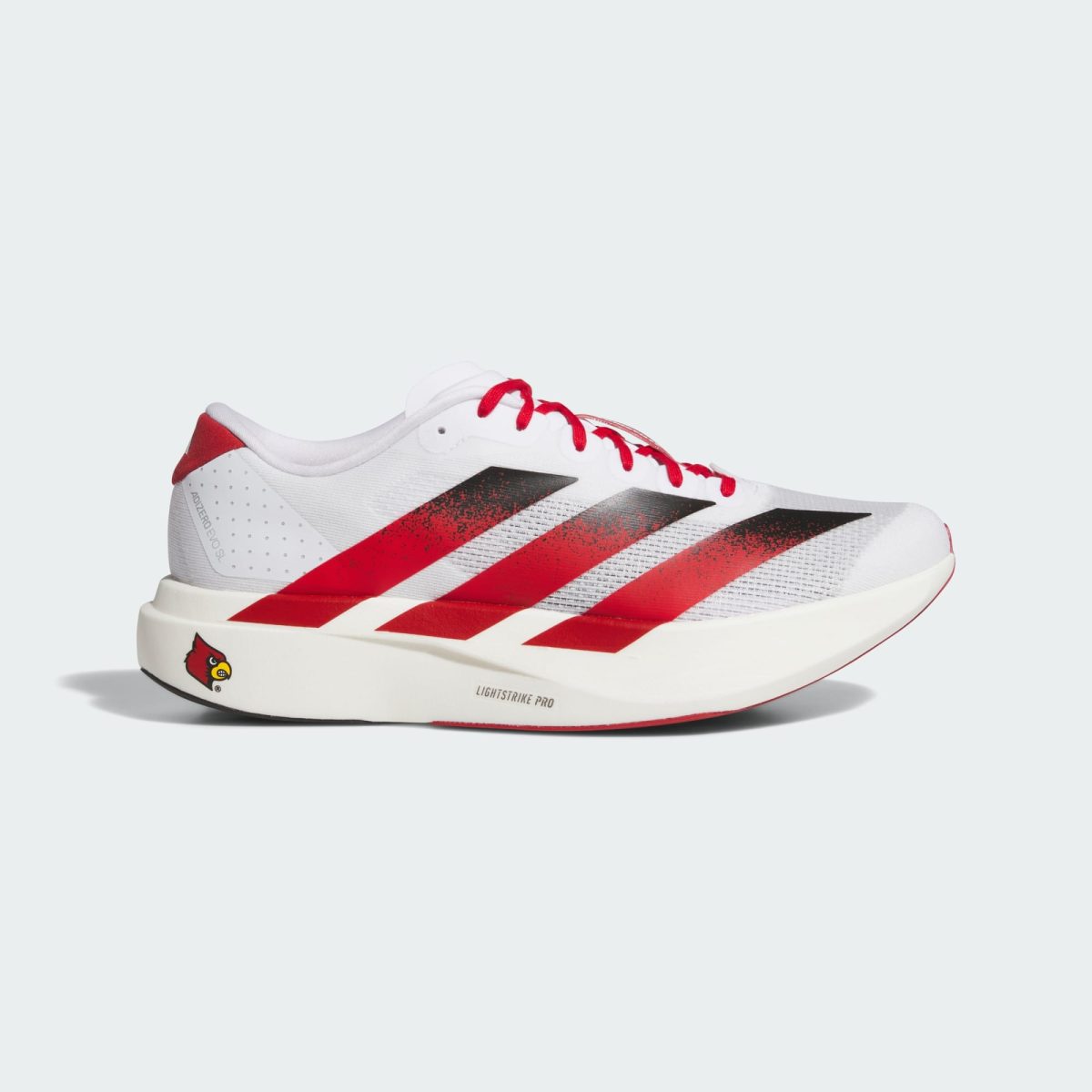White athletic sneaker with red diagonal stripes and red laces, shown from the side with a Cardinal logo near the sole.