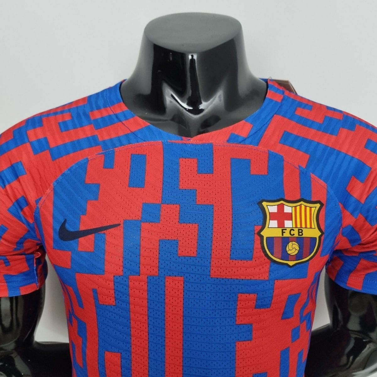 Close-up of a mannequin torso wearing a red-and-blue FC Barcelona jersey with the club crest on the chest and a shiny chrome neck area.