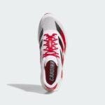 rn-image_picker_lib_temp_249fd74c-f2f5-456d-8aa0-a59a0fa2a8e8 | UAE SPORT STORE Top view of a white and red athletic sneaker with red laces and Louisville branding on the tongue, hanging midair.