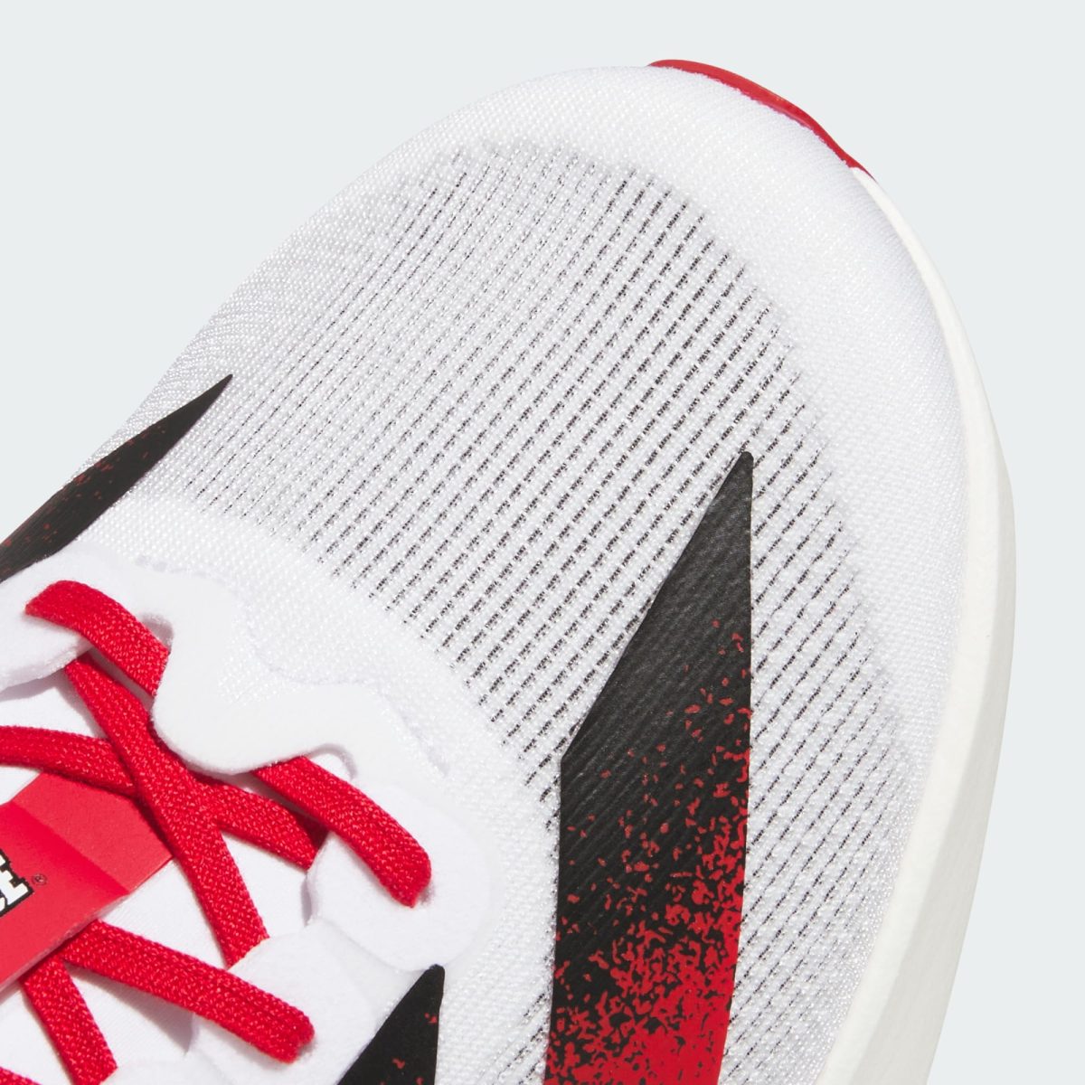 Close-up of a white mesh sneaker with red laces and a black Nike swoosh