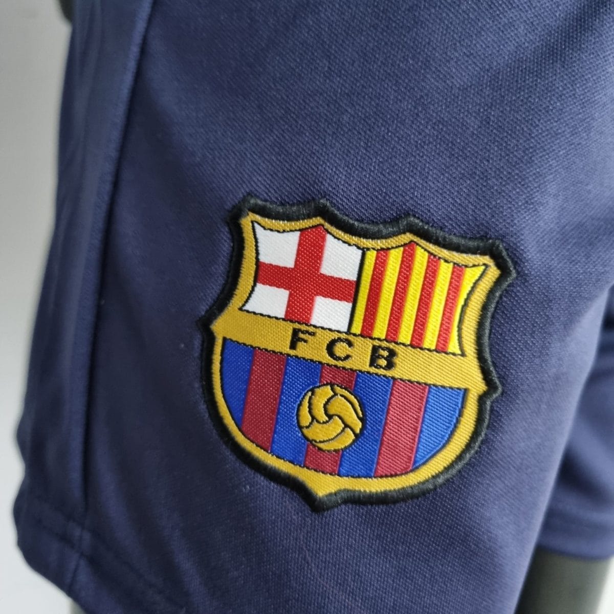 Close-up of FC Barcelona shield badge on a blue jersey.