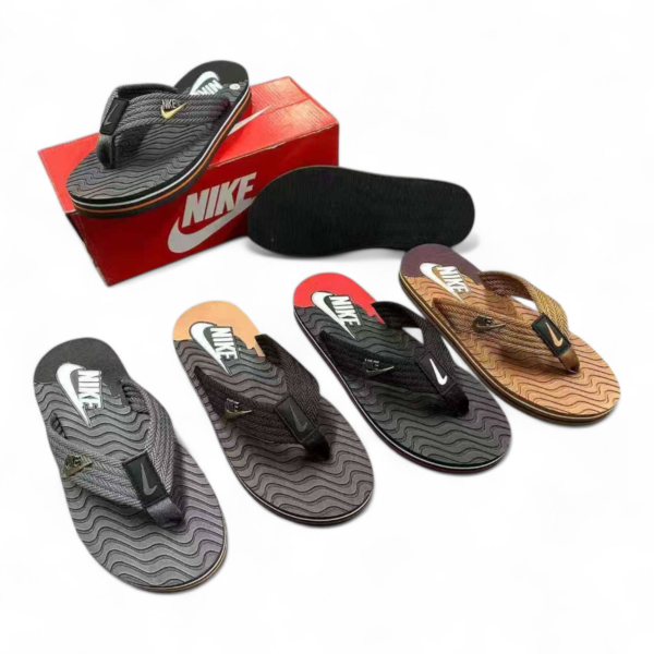 Nike flip-flops and several sandal soles arranged around a red Nike box.