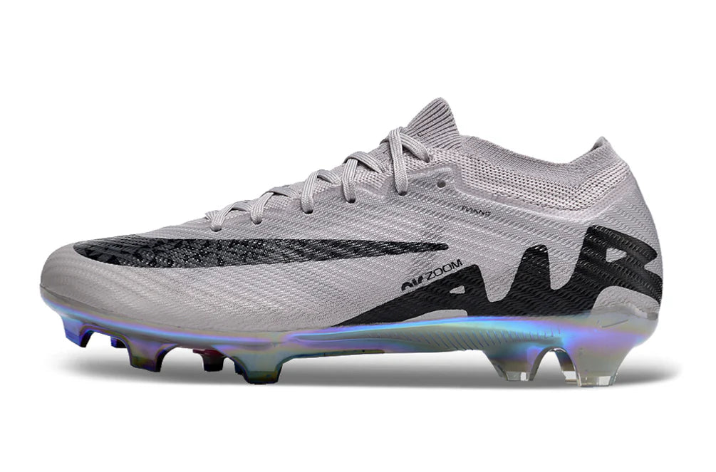 rn-image_picker_lib_temp_35f70505-8462-4178-b640-1d83315d7eef | UAE SPORT STORE Light grey soccer cleat with a knit upper, black graphic accents, and an iridescent multi-color soleplate