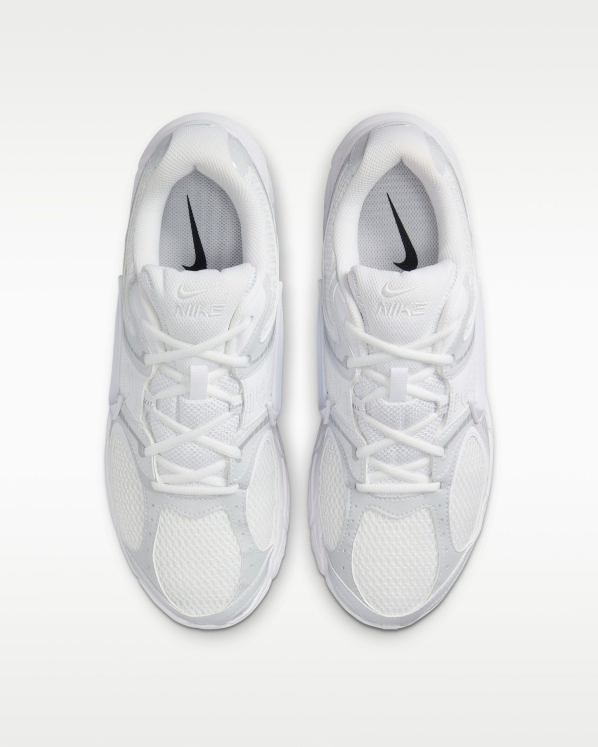 Top-down view of two white Nike sneakers placed side by side on a light background.