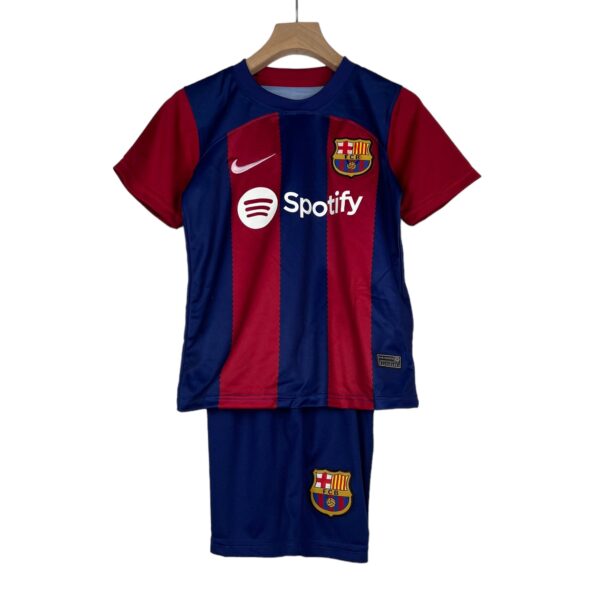 Blue and red FC Barcelona soccer jersey hanging on a wooden hanger, featuring the Nike logo and Spotify sponsor across the chest.