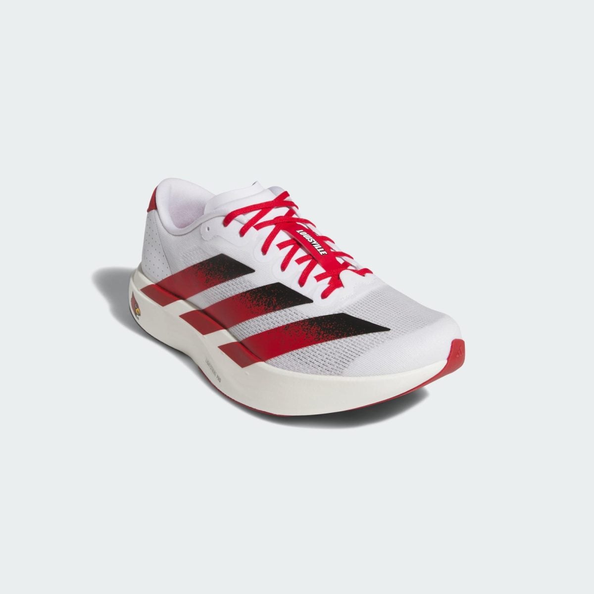 Close-up of a white athletic sneaker with bright red laces against a pale background, showing the front and side details.