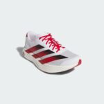 rn-image_picker_lib_temp_45db8b90-3b0f-4468-8ad2-19a4ba0f4a51 | UAE SPORT STORE Close-up of a white athletic sneaker with bright red laces against a pale background, showing the front and side details.