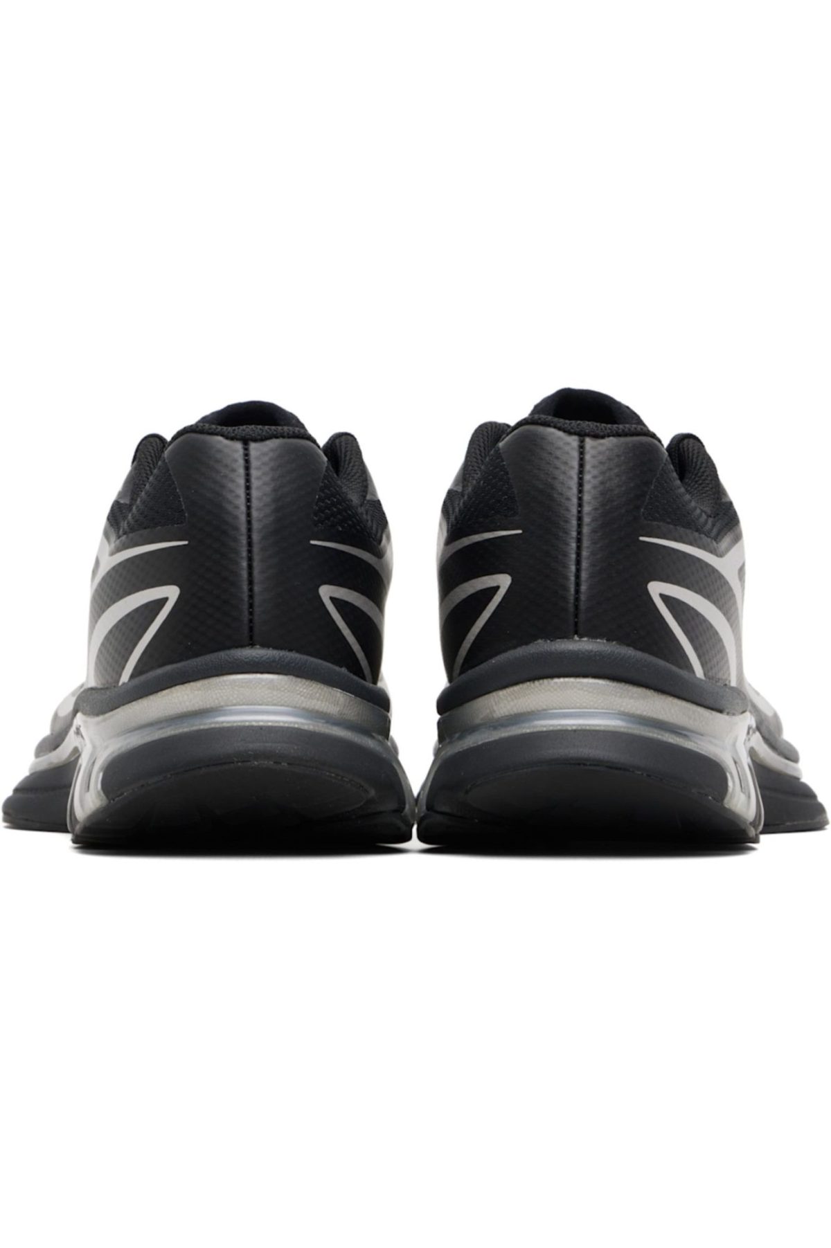 Back view of two black sneakers facing forward, placed side by side on a white background, showing gray sole details.