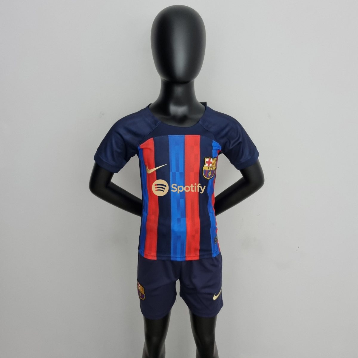 Life-size black mannequin wearing a blue and red FC Barcelona jersey, standing against a plain wall.