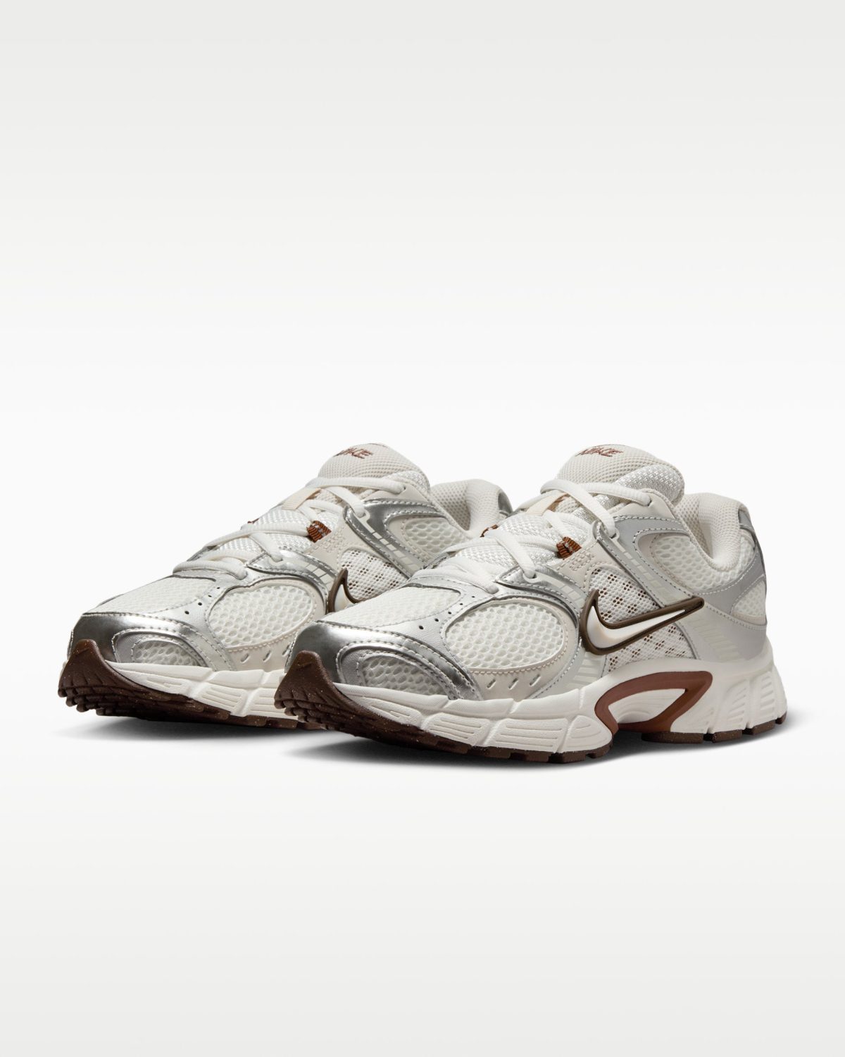 Pair of white and grey athletic sneakers with brown accents on a white background (product photo).