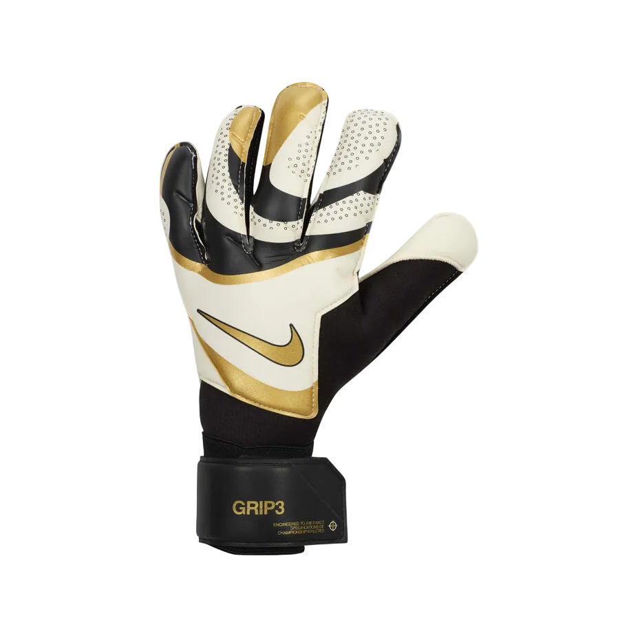rn-image_picker_lib_temp_52999ca7-9550-4df6-88bc-7cbaeabb2d2d Nike goalkeeper glove in white, black, and gold with a gold swoosh and Velcro wrist strap marked GRIP3.