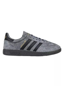 Grey suede Adidas sneaker with black three stripes and textured midsole, side view