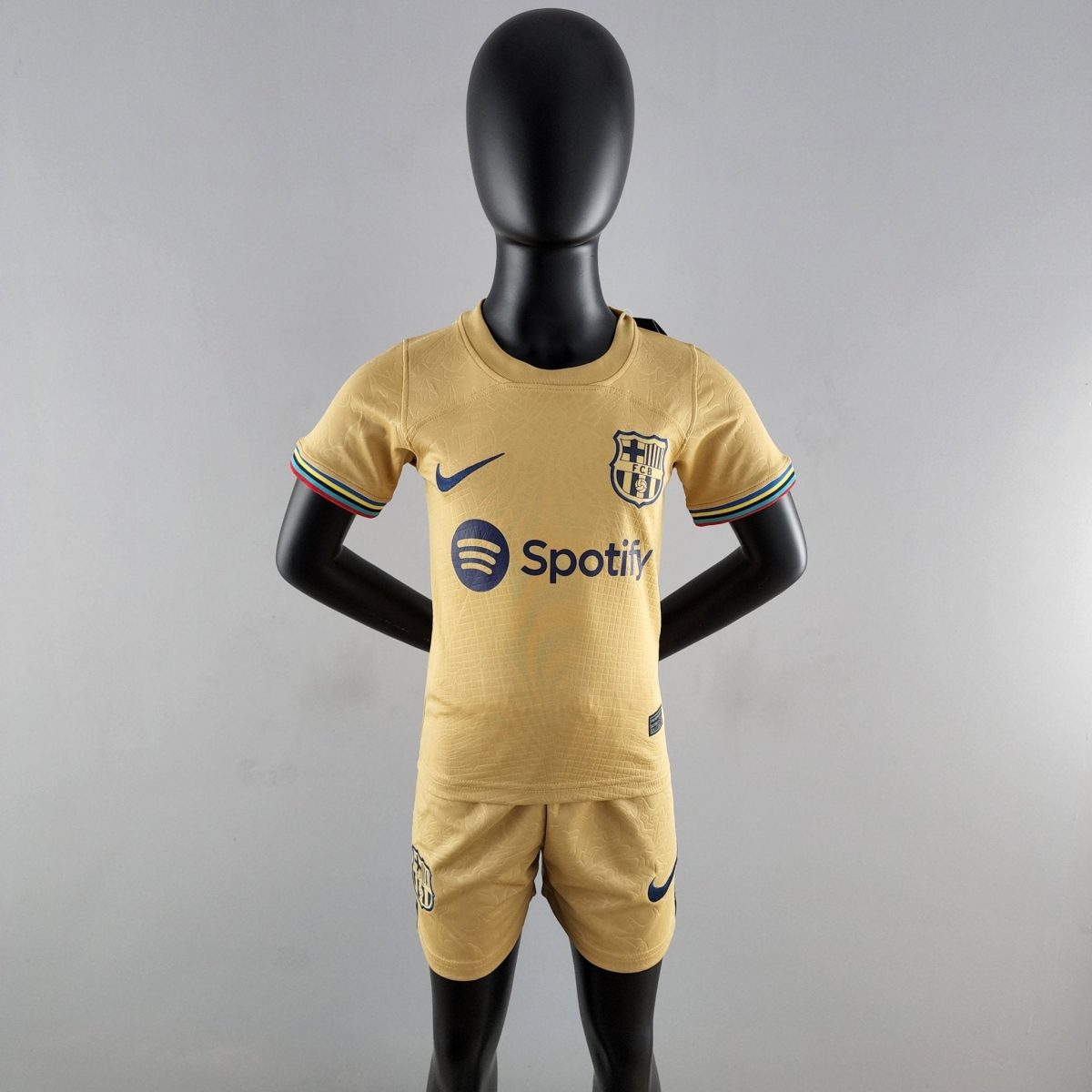 Black mannequin wearing a yellow FC Barcelona soccer jersey with Nike logo and Spotify sponsor text and emblem, front view.